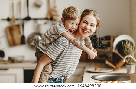 preparation of a family breakfast. mother and child son cut bread and eat cookies with milk in morning
 Royalty-Free Stock Photo #1648498390