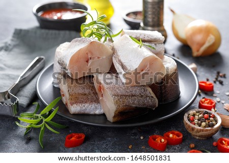 Raw fresh sliced hake fish with ingredients for cooking
