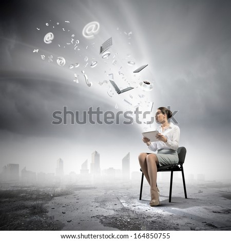 Image of businesswoman sitting on chair with tablet pc in hands