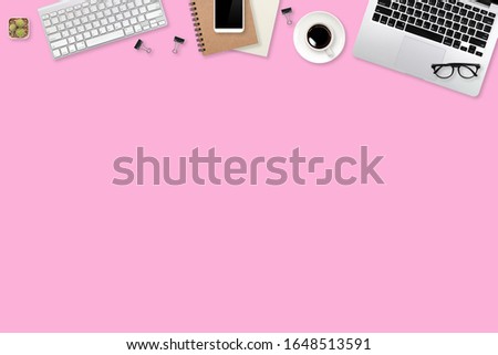flat lay workspace table with laptop computer, office supplies, coffee cup, tablet and cell phone on pink pastel background