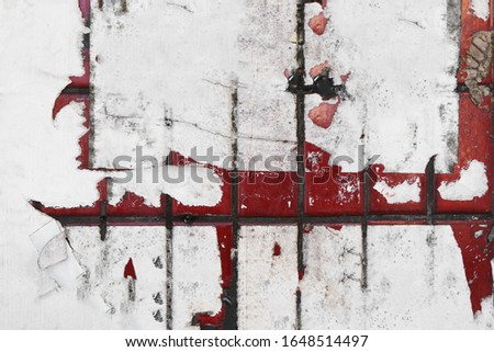 Red worn urban exterior wall tiles with torn street poster paper