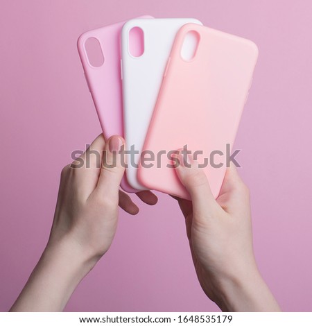 hands holding three colorful smartphone cases isolated on pink background, iPhone X phone cases