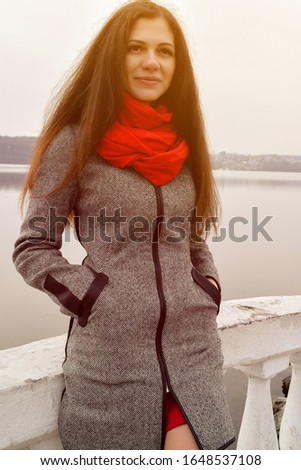 Beautiful girl in grey coat walking in the street. Beautiful smiling brunette outdoors