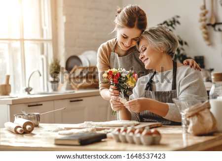 happy mother's day! family old grandmother mother-in-law and daughter-in-law daughter congratulate on the holiday, give flowers  Royalty-Free Stock Photo #1648537423
