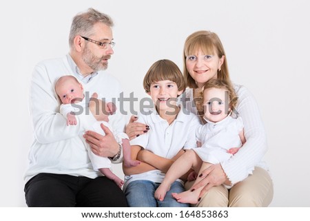 Happy loving couple having fun with three kids, teenage boy, toddler girl and a newborn baby