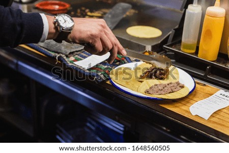 close up of chef making tacos in a restaurant at lunch time