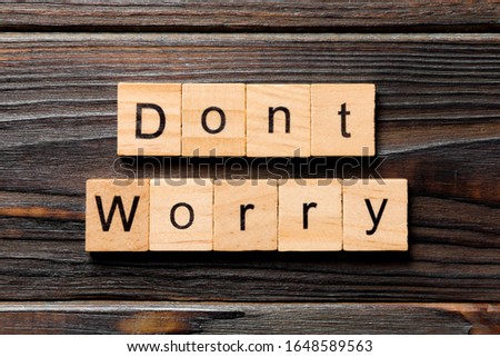 Don't worry word written on wood block. Don't worry text on wooden table for your desing, Top view concept.