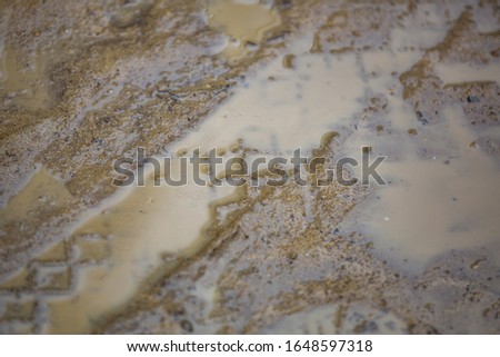 Clay, soil and dirt on a textured brown road on a rainy day
