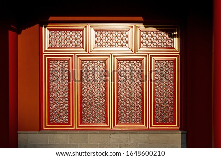 Part of Chinese traditional palace building, resplendent red painted windows decorated with golden frame and grid 