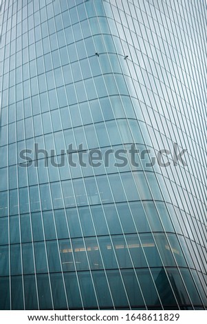 Close up view of a modern high skyscraper in the financial centre of Milan made of glass, metal with geometrical lines dividing windows of the building. European architecture. Milan, Lombardy, Italy