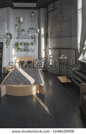 dark design of huge studio apartment in loft style with big windows and black wooden contemporary furniture with free planing. funny bed inside. sleeping area. sunshine.