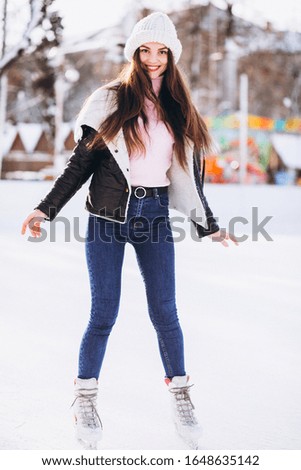 Young woman skating on a rink in a city center