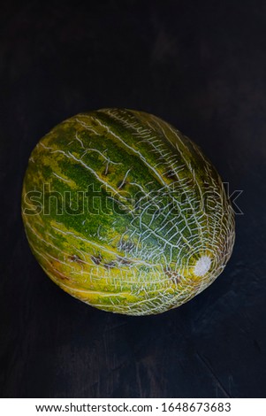 Whole toad skin melon on black background