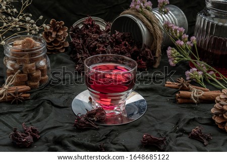 Roselle tea (Jamaica sorrel, Rozelle or hibiscus sabdariffa ) with dry roselle and brown cane sugar cube. Healthy herbal tea rich in vitamin C and minerals. The concept of health. Selective Focus.