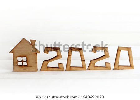 mock up of a wooden house with the number 2020 on a light background front view. ecological real estate