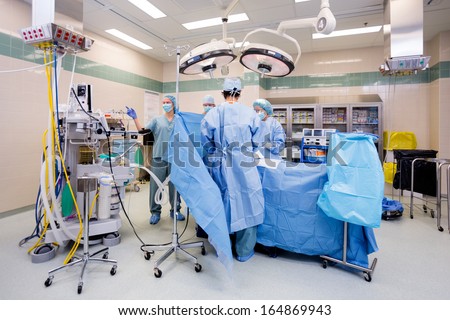 Surgical team operating on patient in theater in hospital Royalty-Free Stock Photo #164869943