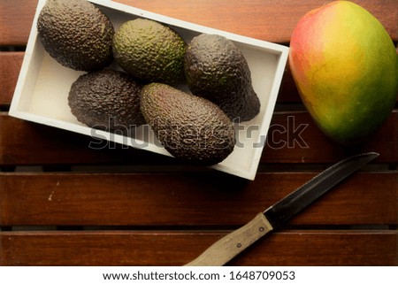 Heart of life, multiple benefits of mango, accompanied by avocados in a white box.