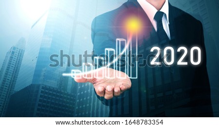 Man standing and shows outstretched hand with Bar Visual Graphic open palm on Light of Len flare and Bokh Blue Building  background. COPY SPACE. Market Uptrend 2020.