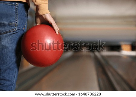 Man with ball in bowling club, closeup. Space for text