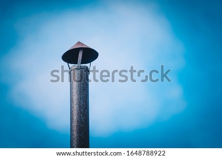 Iron pipe from furnace on background of blue sky