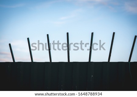 High fence of corrugated board with iron pins to protect the territory