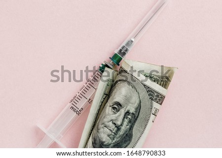 American dollar with Benjamin Franklin and empty syringe on pink background, concept of drugs, spread and dirty money, flat lay with copy space