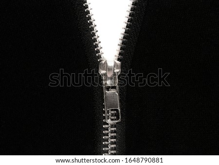 Open zipper or clothes lock on black fabric, close up photo