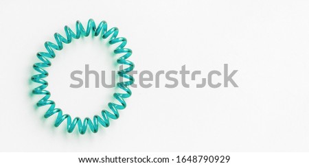 Aqua Menthe spiral rubber band. Elastic hair tie on white background close-up, copy space for text