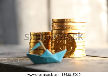 startup concept, graph of gold coins and a paper boat