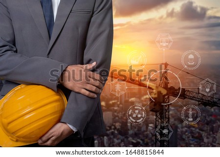 Double exposure of Engineer with safety helmet with construction cranes no city background.