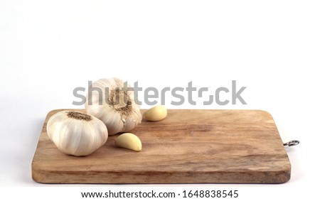 Garlic and garlic cloves on a wooden cutting board,Selective focus,
On white background. Royalty-Free Stock Photo #1648838545