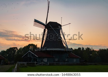 a windmill with a beautiful sunset behind it in Deventer the Netherlands