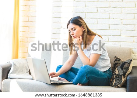 young attractive woman at home tiredly seeking for a job or rent in internet