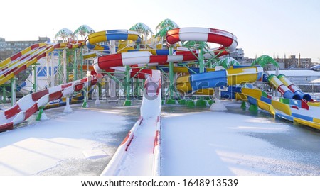 Dnipro, Ukraine: Big colorful water slide fun park with swimming pool and blue sky with snow. 
February 10, 2020
