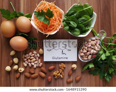Food rich in glutamine with structural chemical formula of glutamine molecule. Food for training and exercise: spinach, eggs, parsley, carrot, beans, almond, walnut. Bodybuilding, sport nutrition. Royalty-Free Stock Photo #1648915390