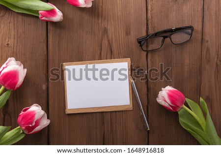 Pink tulips on wooden background. Flat lay, top view. Copy space.