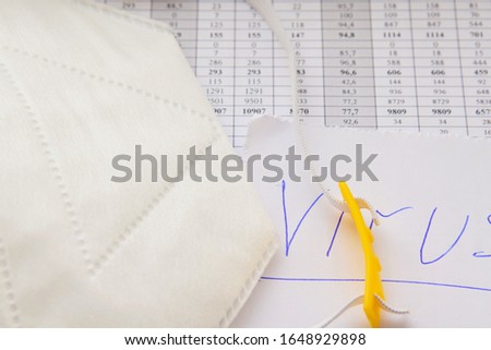 a protective medical dressing, a paper with a catch virus and a pen are on the statistical tables