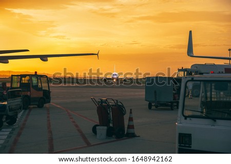 Airplane landing at the airport at sunset