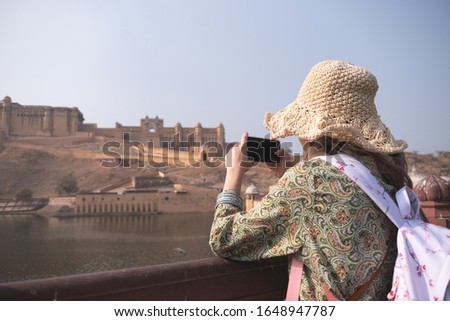 Young woman capture photo of Amber Fort in Rajasthan state of India 