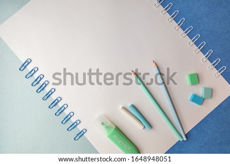 Stationery for school and office in pastel colors on a blue and white background, top view, there is space for text. Back to school. Creative school concept.