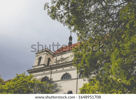 Toned photo of beautiful spire on the roof of catholic cathedral against cloudy sky