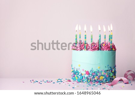 Pastel colored birthday cake with sprinkles and pink buttercream swirls