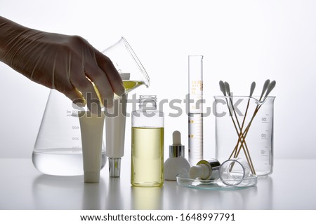 Dermatologist formulating and mixing pharmaceutical skincare, Cosmetic bottle containers and scientific glassware, Research and develop beauty product concept. Royalty-Free Stock Photo #1648997791