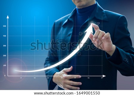 Businessman drawing an exponential curve of a progress in business growth performance, return on investment - ROI, on a virtual screen presentation. Royalty-Free Stock Photo #1649001550