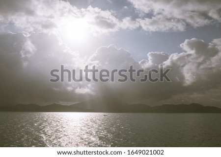 Beautiful blue and turquoise sea in Thailand in the Gulf of Thailand. Samui island.A horizon with islands and hills is seen.Boats sailing.Calm and waves.Rainbow and beautiful clouds after rain.The sun