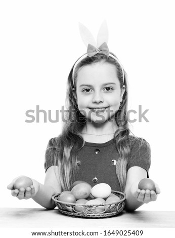 small baby girl or cute child with happy face wearing rabbit pink ears with purple blouse showing colorful easter eggs isolated on white background