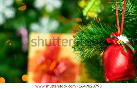 A green Christmas tree with a red bag, bow, background with a gift box to give away.