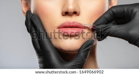 Young caucasian woman getting botox cosmetic injection in the lips. Beautiful woman gets botox injection in her face. Adult girl gets cosmetic injection of botox in a clinic. Beauty treatments Royalty-Free Stock Photo #1649066902