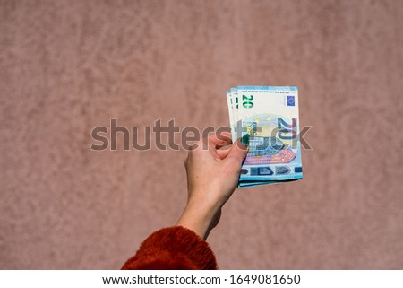 Hand holding showing euro money and giving or receiving money like tips, salary. 20 EURO banknotes EUR currency isolated. Concept of rich business people, saving or spending money.