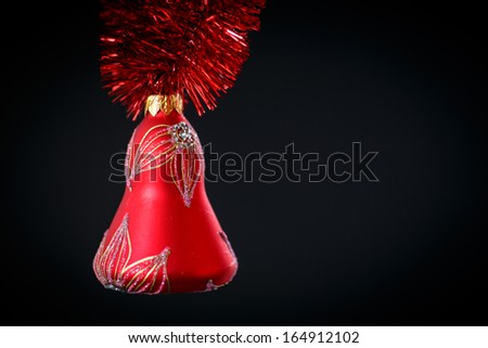 Christmas bell with red garland on a black background